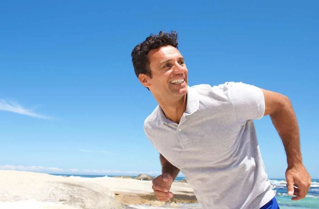 Man on beach smiling.