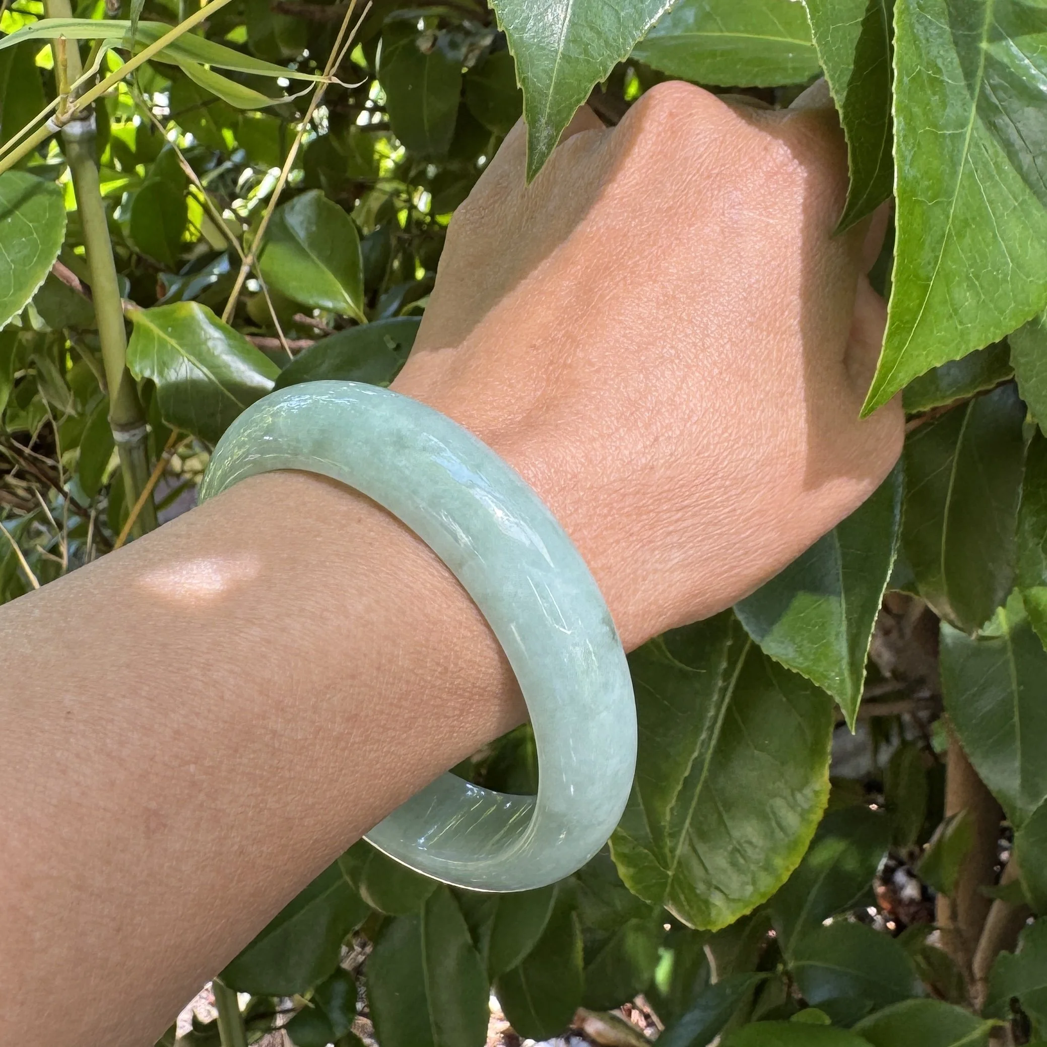 natural apple green jadeite bangle bracelet worn on the wrist