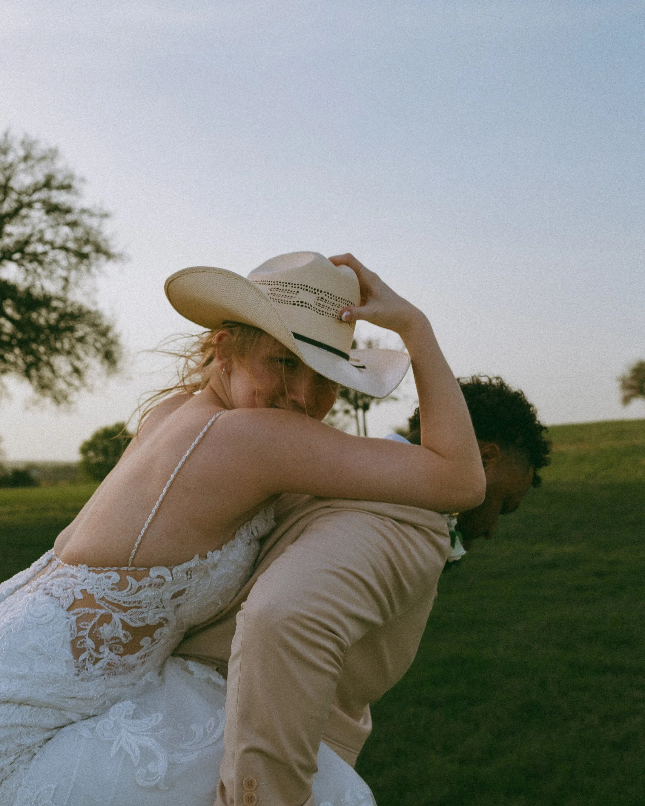 Bride laughing during playful cinematic wedding portraits in a field