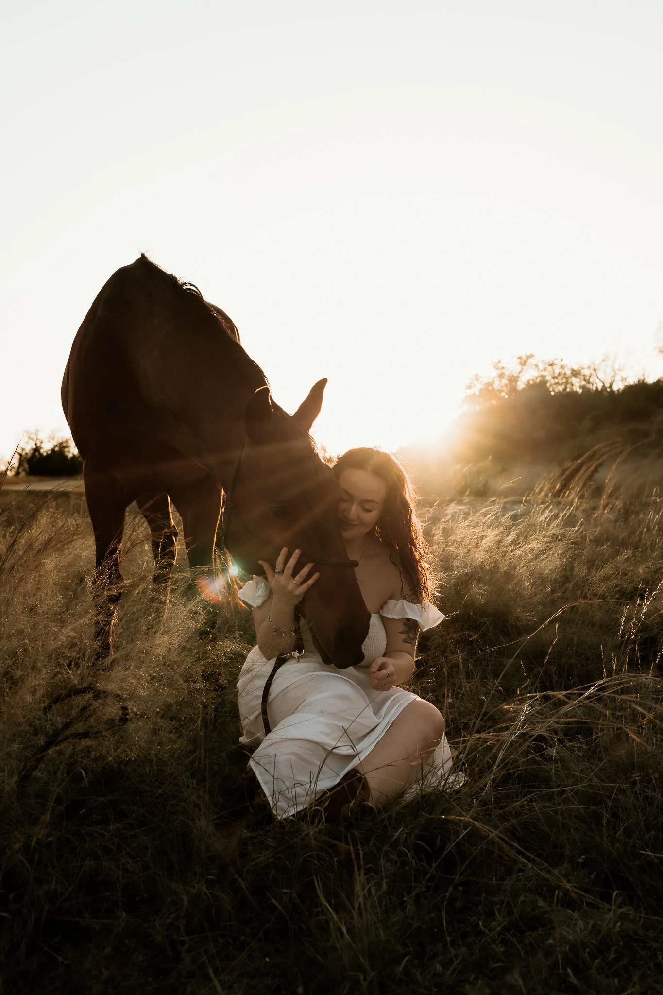 A senior shares a quiet moment with their horse, gently pressing their forehead against its muzzle, capturing the essence of ranch life.