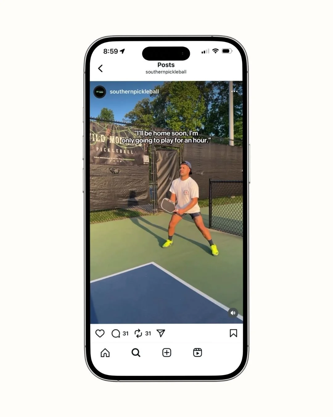 A young man playing pickleball on an outdoor court, wearing a baseball cap backwards, white T-shirt, shorts, and bright yellow sneakers, holding a pickleball paddle, with trees in the background.