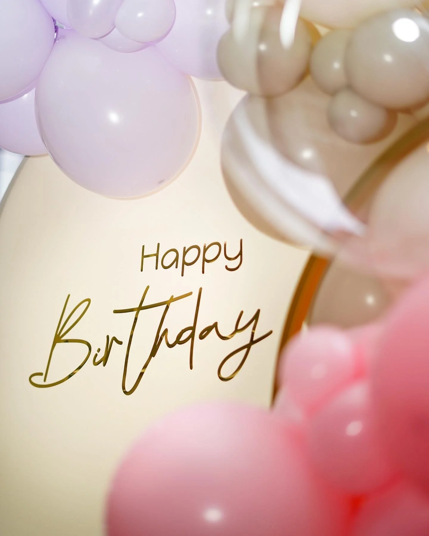 A birthday card decorated with pink and white balloons with the message 'Happy Birthday' written on it.