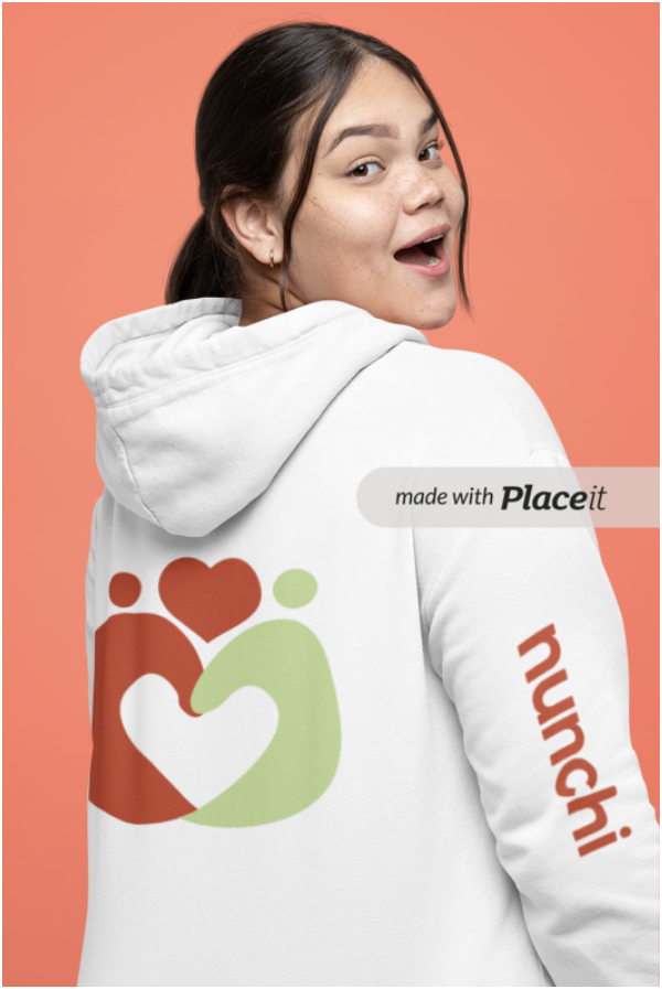 A young woman with dark hair, wearing a white hoodie with a colorful heart and figure design on the back and the word 'nunchi' printed on the sleeve, smiling and looking over her shoulder against a peach-colored background.
