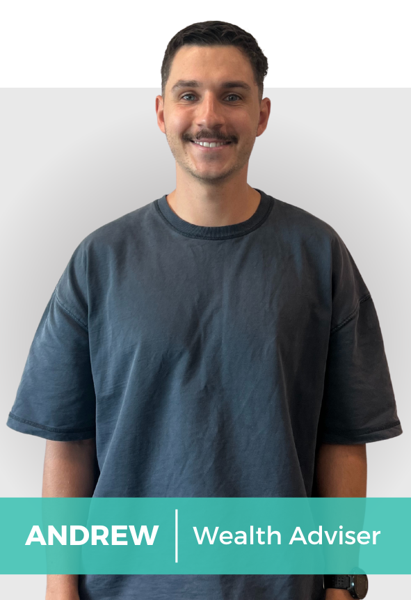 A young man with short dark hair and a mustache smiling at the camera, wearing a dark gray T-shirt, standing against a plain light gray background.