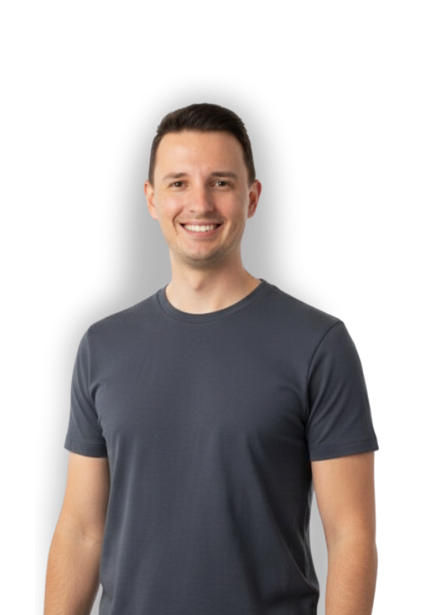 A smiling young man wearing a dark gray T-shirt, standing against a black background.