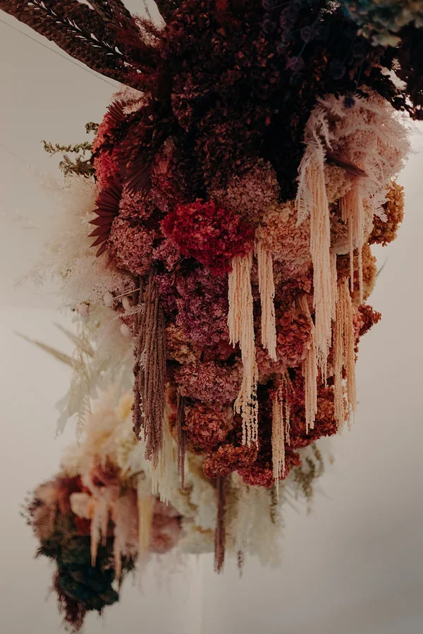 Garden Graffiti florist selecting and arranging dried flowers during construction of the floral artwork at West Village.