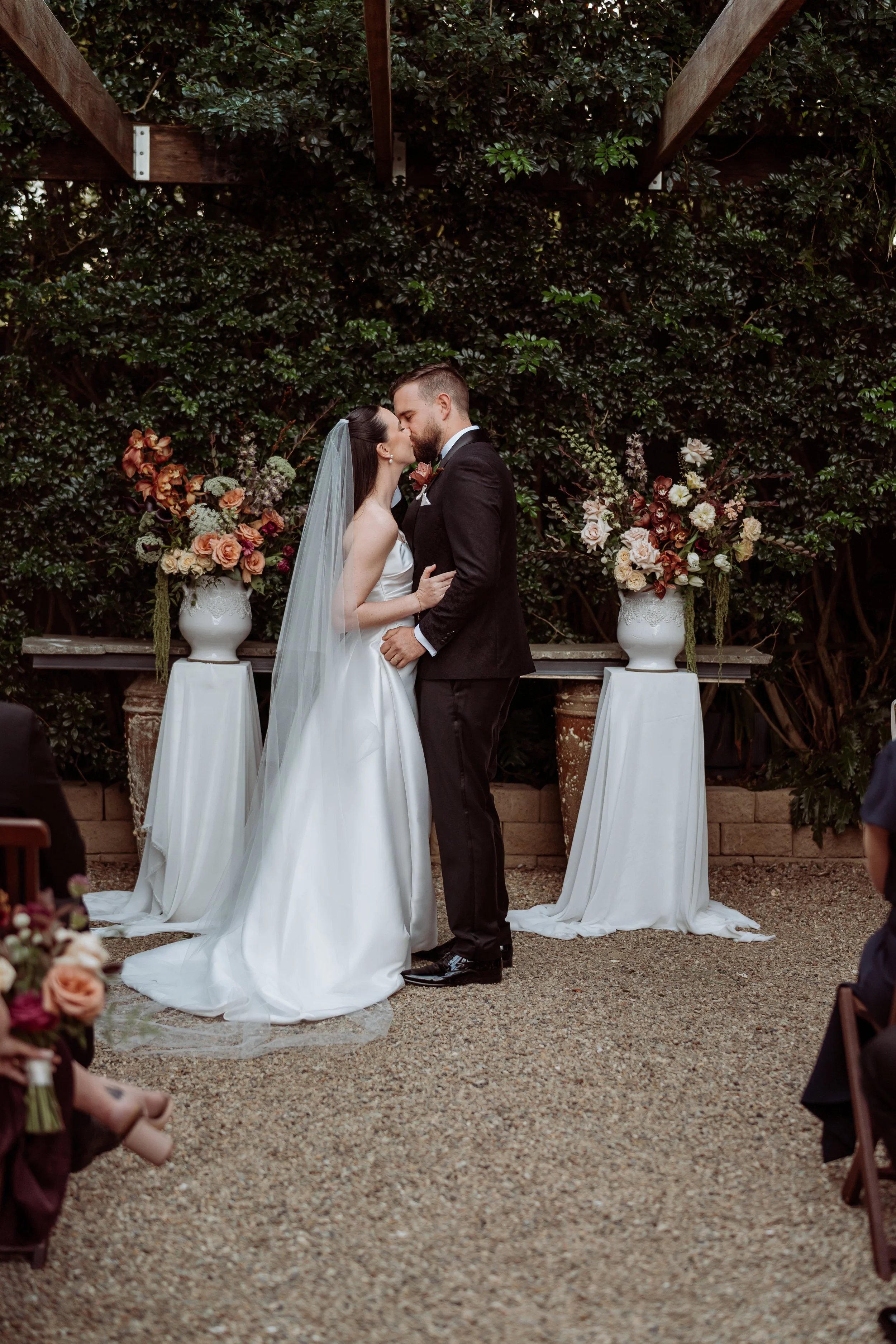 Newlywed kiss at Hillstone St Lucia Brisbane with wedding flowers