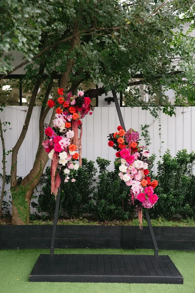 Abstract venue arbour with bold coloured floral placed asymmetrically on structure for a modern wedding look