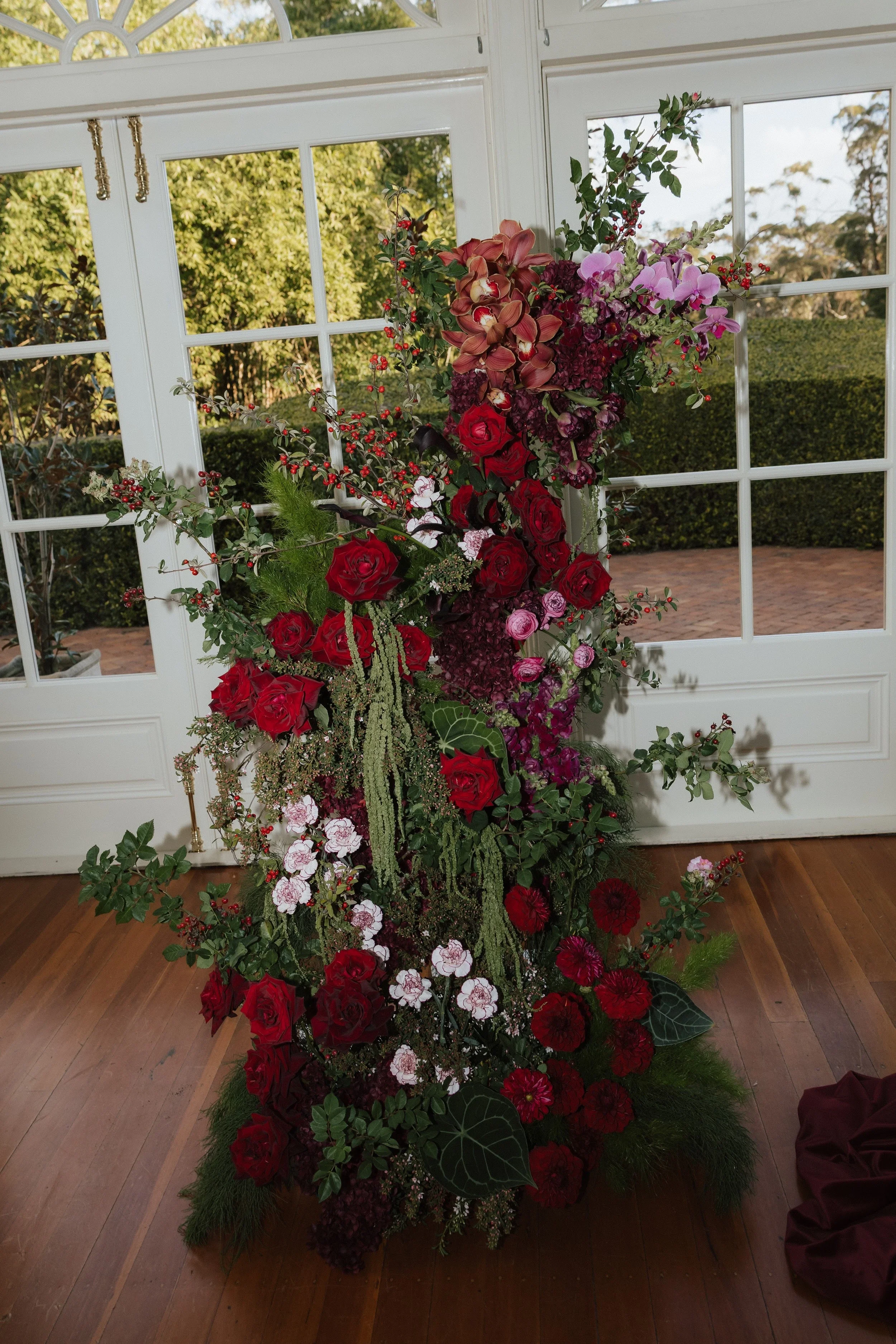 Deep red and pink floral install climbing beside the conservatory windows at Gabbinbar Homestead