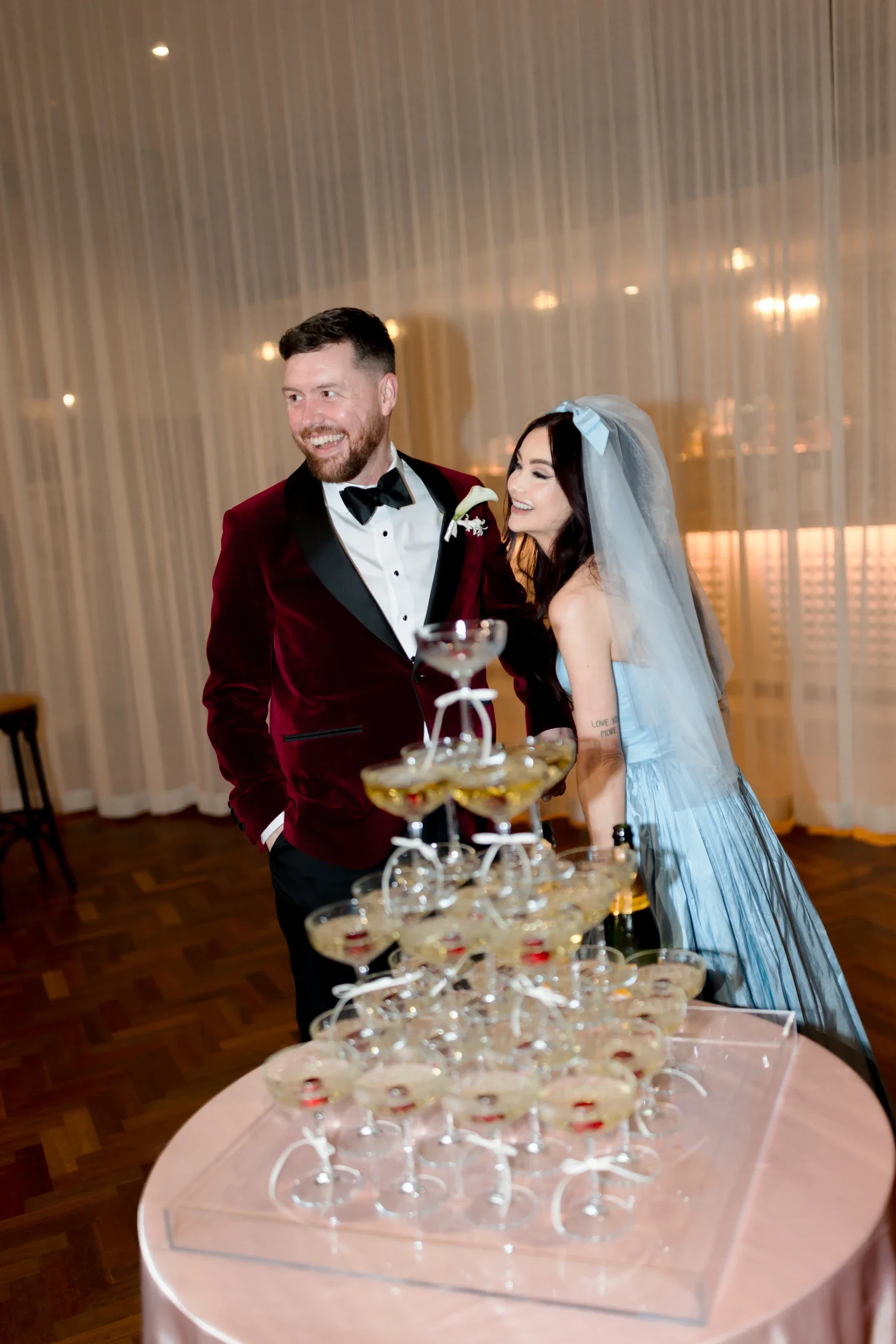 Bride and groom with a champagne tower at their reception