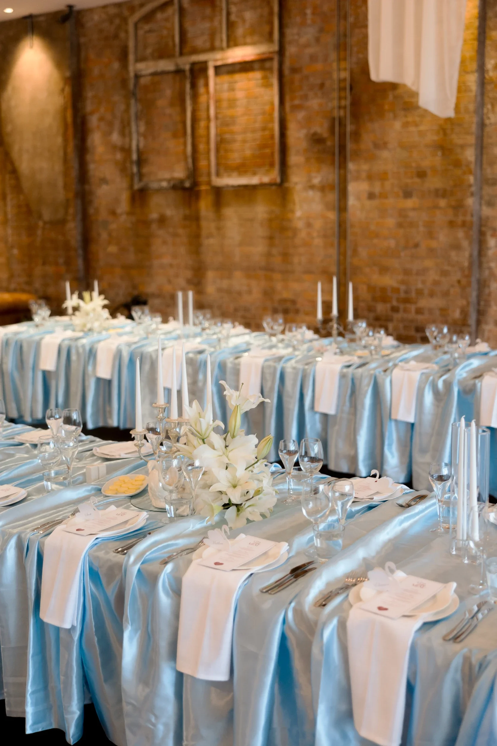 Long reception tables with powder blue satin and white floral centrepieces at The Warehouse Brisbane
