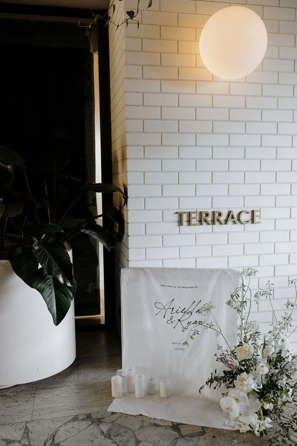 Entrance display at The Terrace featuring the wedding welcome sign accented with orchids and candles.