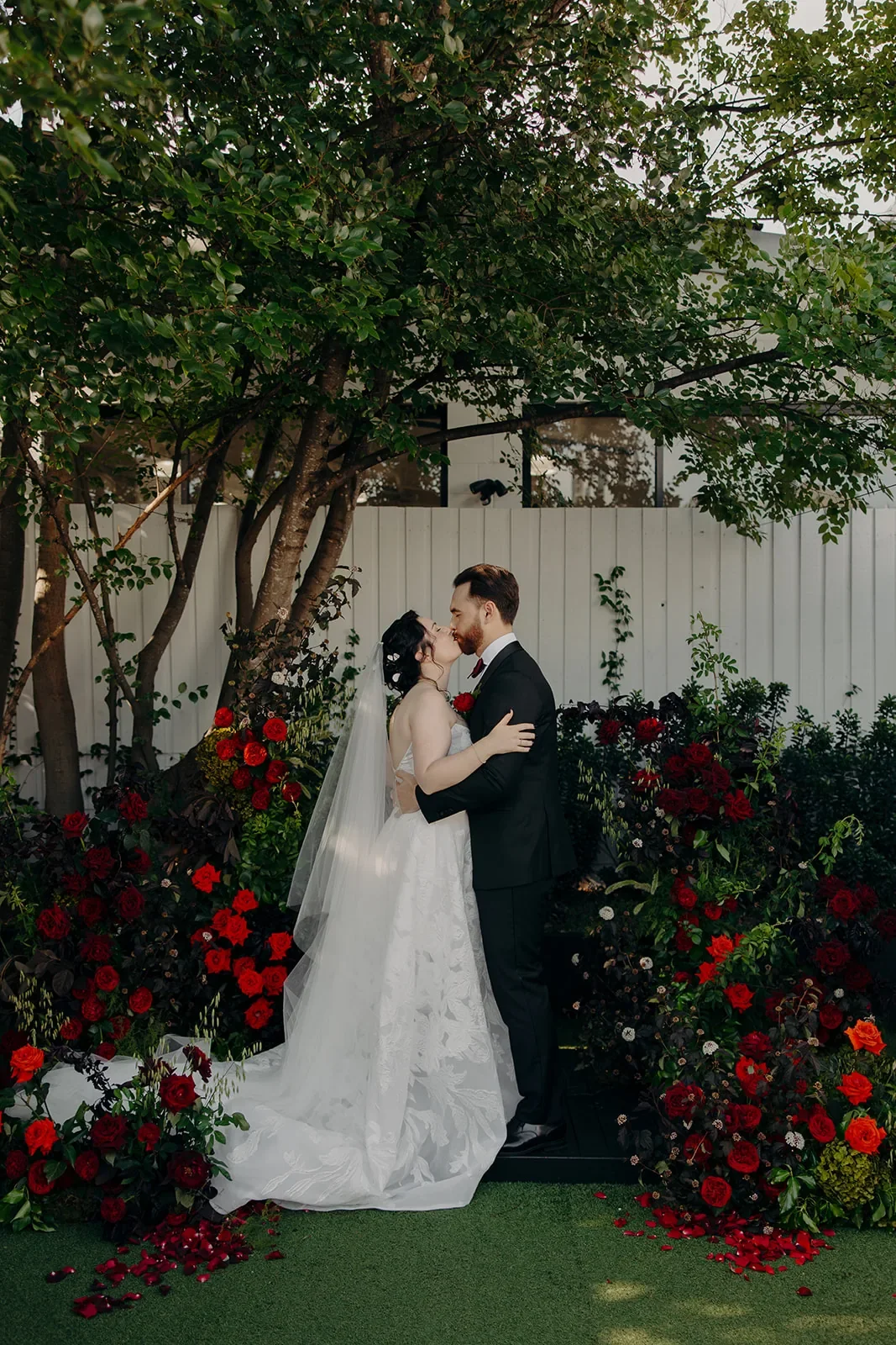 Romantic Wedding Arbour with Newlyweds featuring red roses in Brisbane.