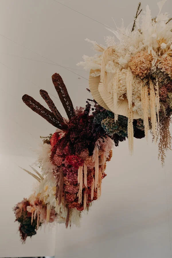 Exterior view of West Village showing the large-scale hanging floral installation by Garden Graffiti inside the venue.