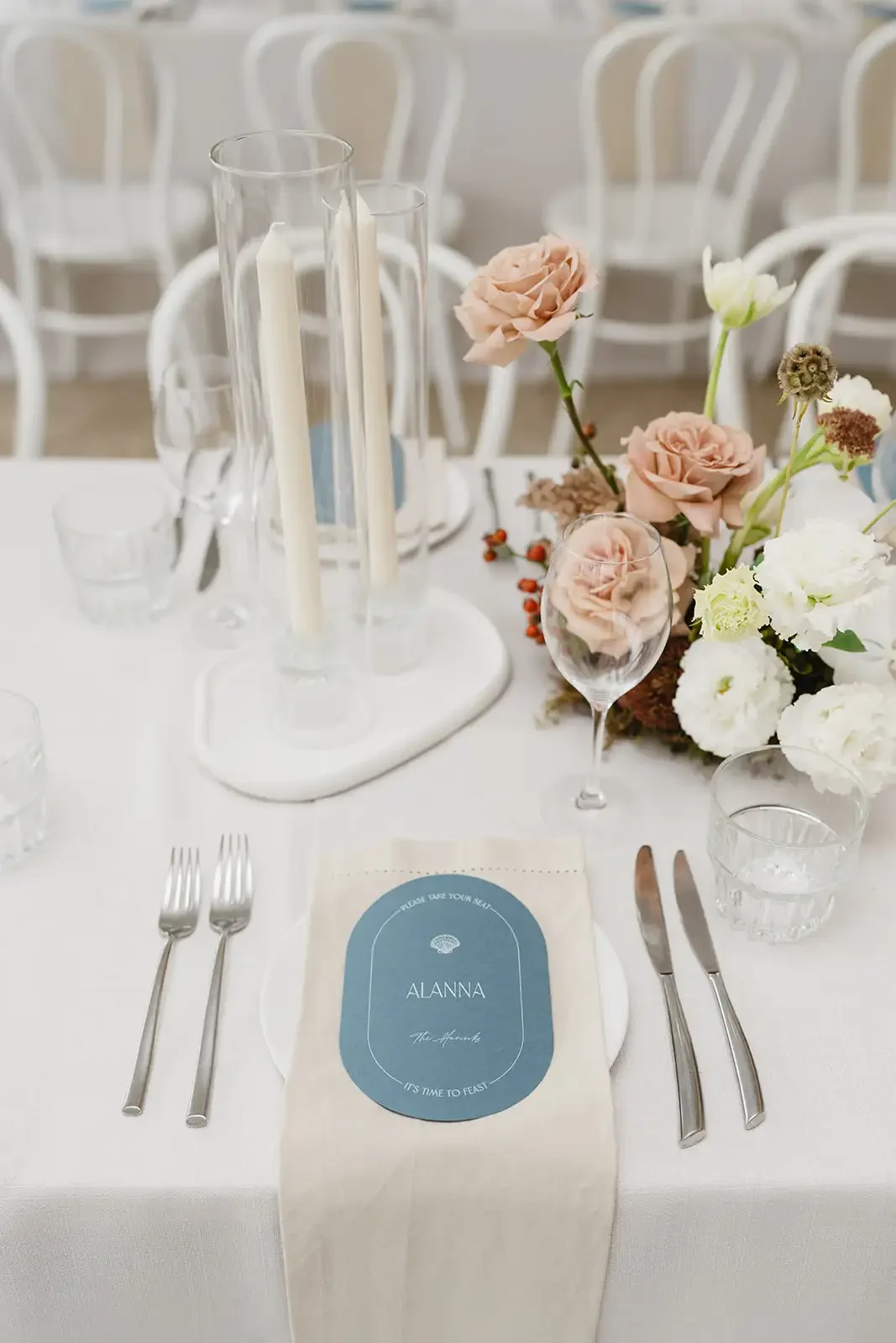 Reception tablescape featuring blush roses, candles and natural floral centrepieces.