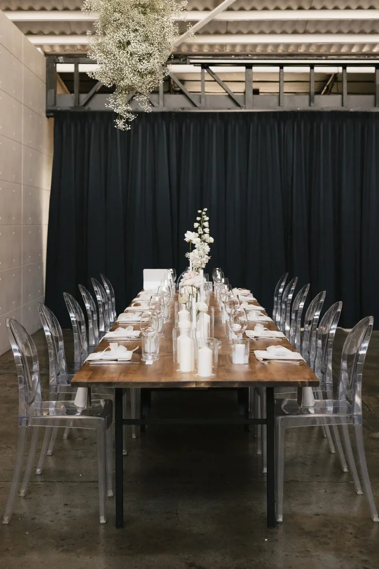 Soft, airy baby’s breath installation suspended above the reception table, illuminated by warm lighting.