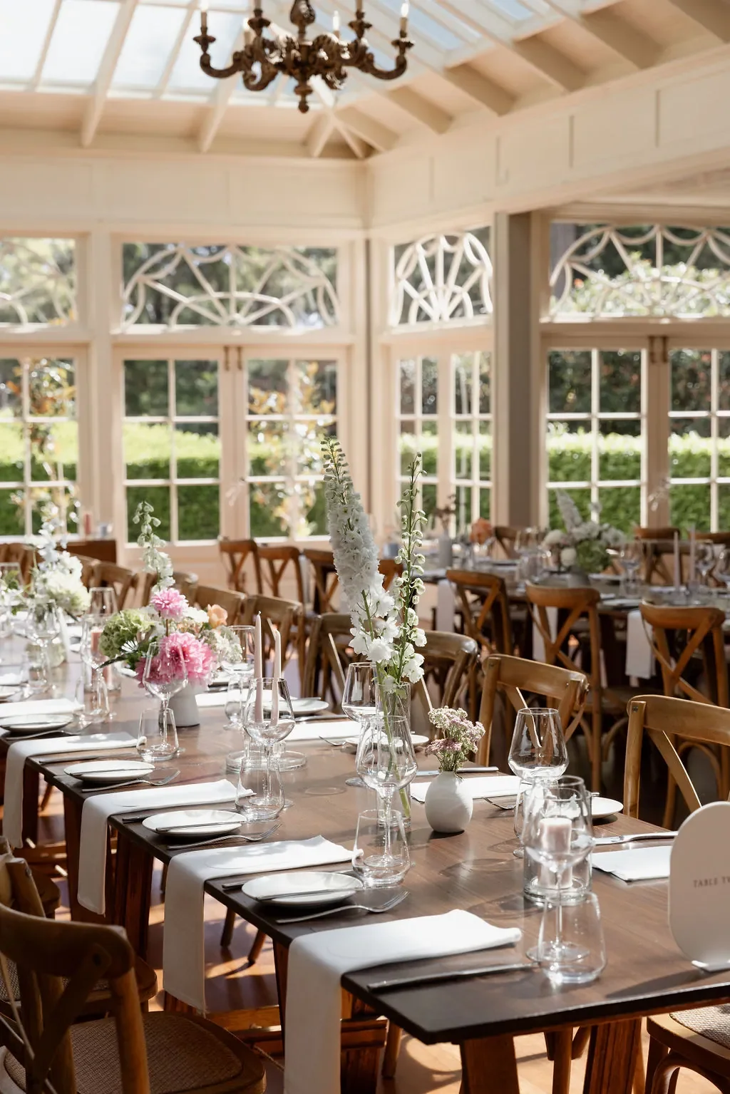 Elegant wedding reception tables styled with minimalist floral arrangements in a light-filled Scenic Rim venue.