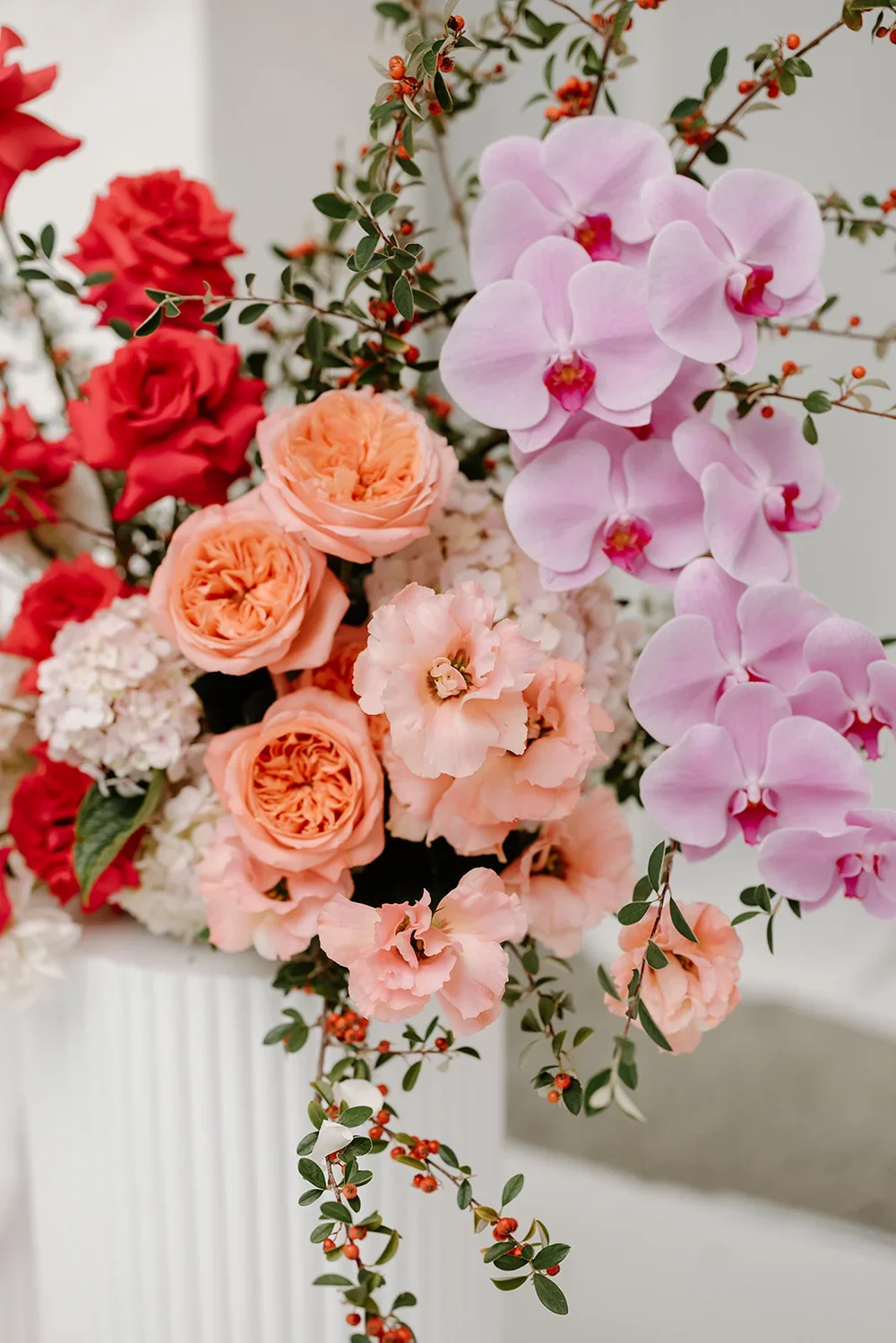 Close up of lavender orchids, peach lisianthus, peach roses and pink roses.