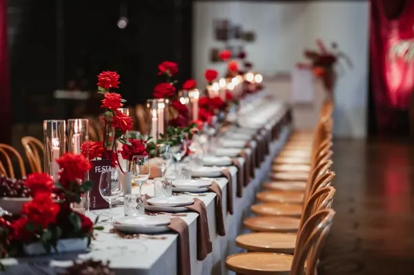 Red florals, candles and rustic Italian table styling for an event designed by Brisbane florist Garden Graffiti.