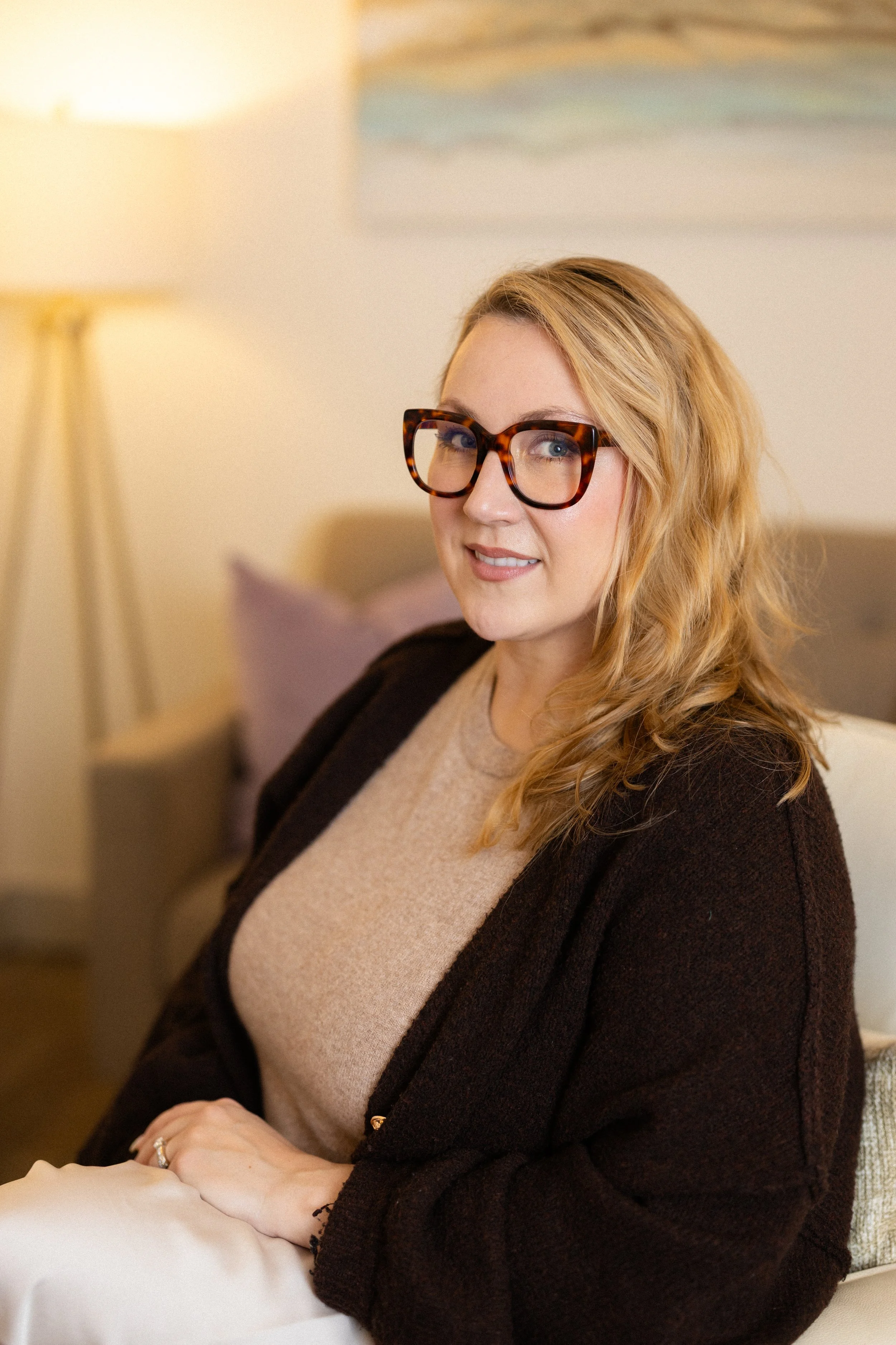 Anne Falabregues, woman with blonde hair and brown glasses, smiling