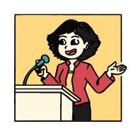 Modern building with wooden and metal exterior, large glass front, surrounded by low shrubs, with mountain range in background.