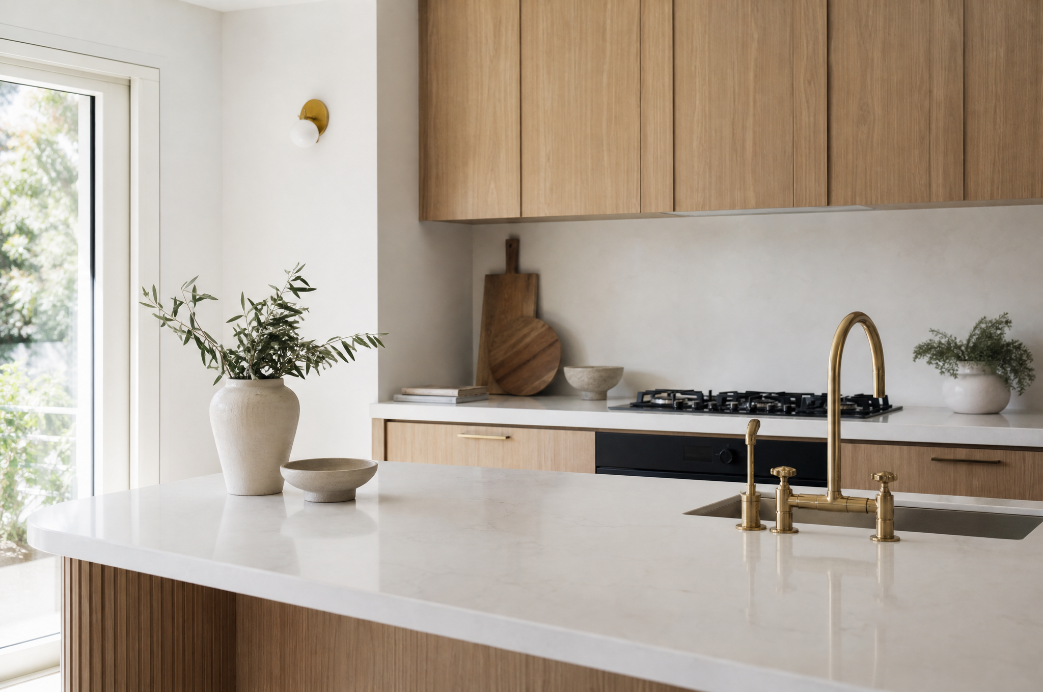 Bright Rose Bay kitchen with stone benchtops and aged brass tapware by Tuesday Lane