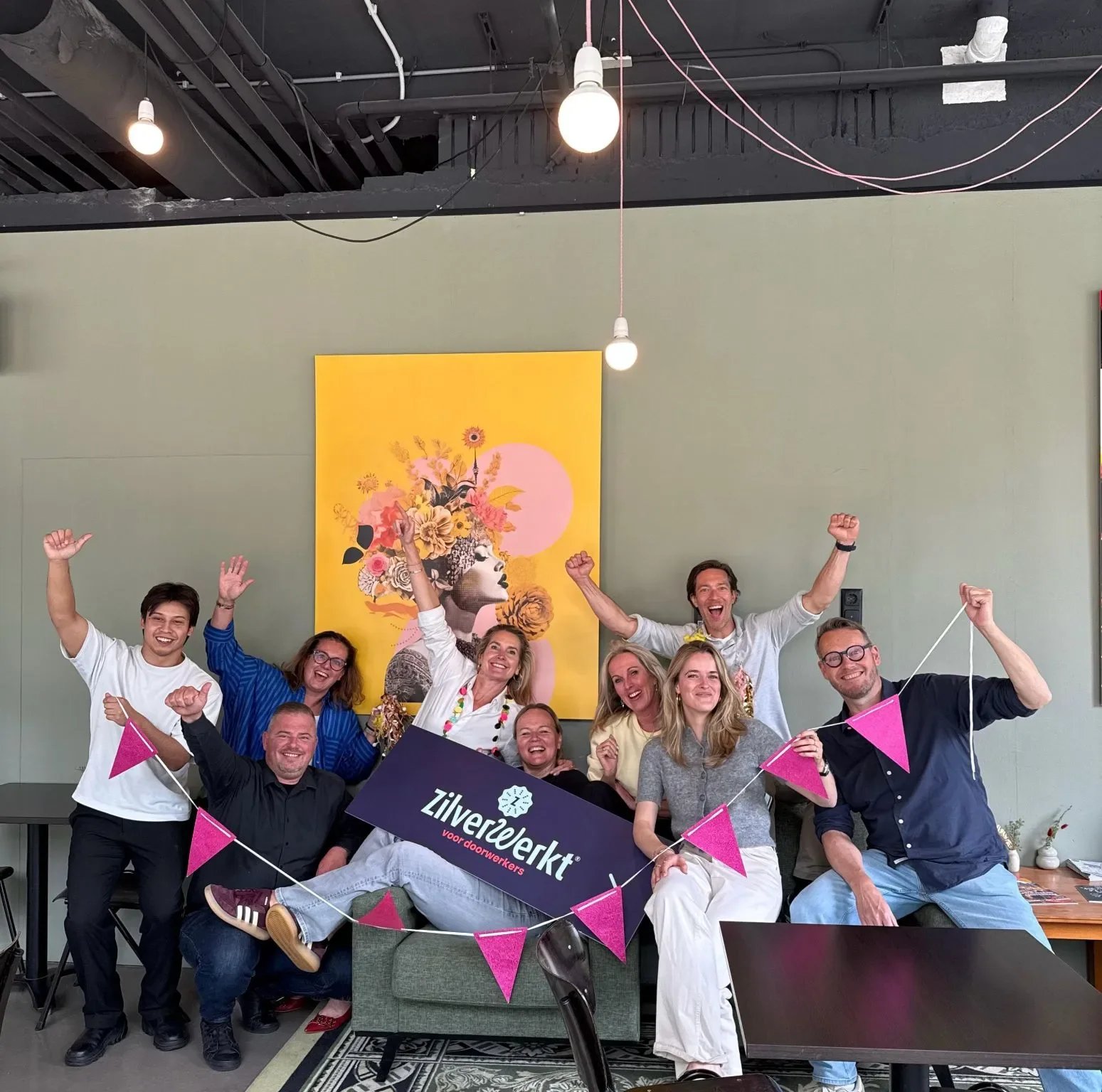 Het team van ZilverWerkt viert juichend de nominatie voor de HR Changemaker Award 2026, met een ZilverWerkt-banner en slingers op kantoor.