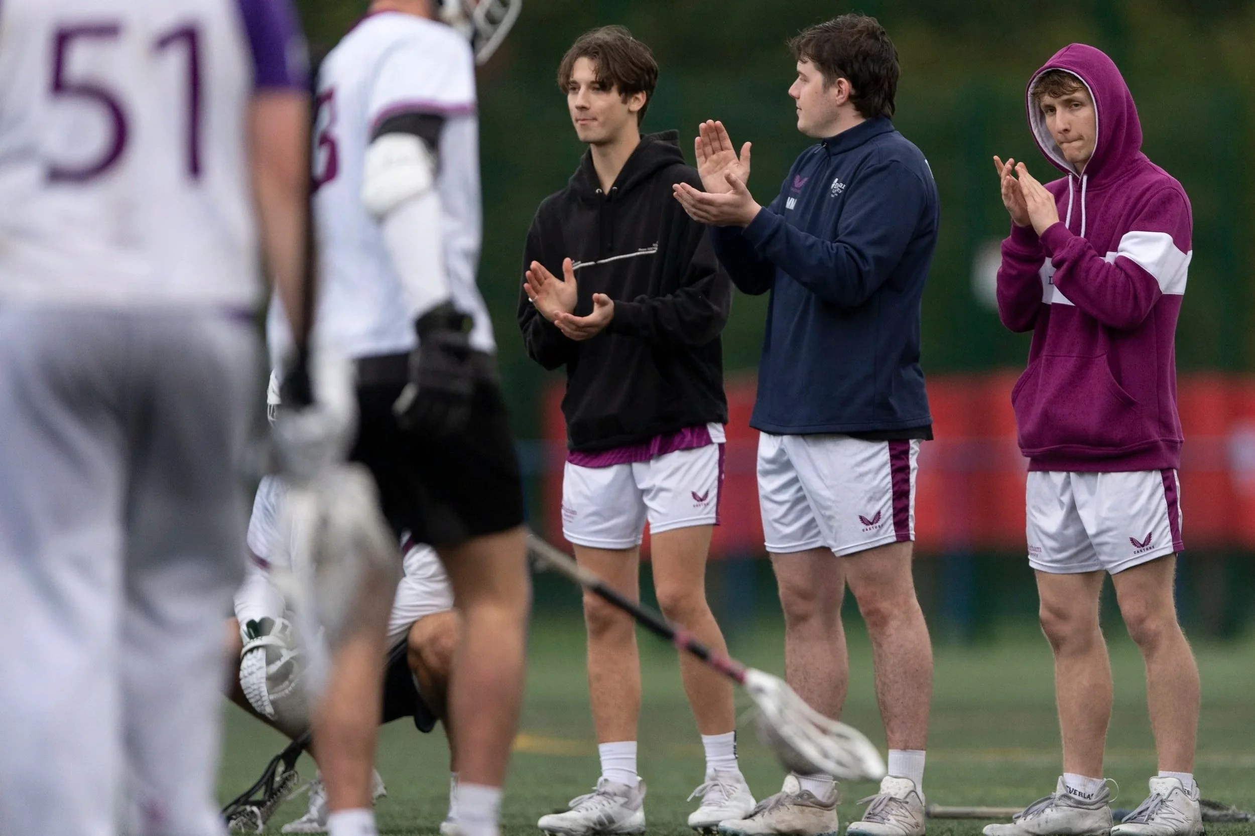 Three players clap on the sidelines at BUCS Lacrosse Sixes Championships