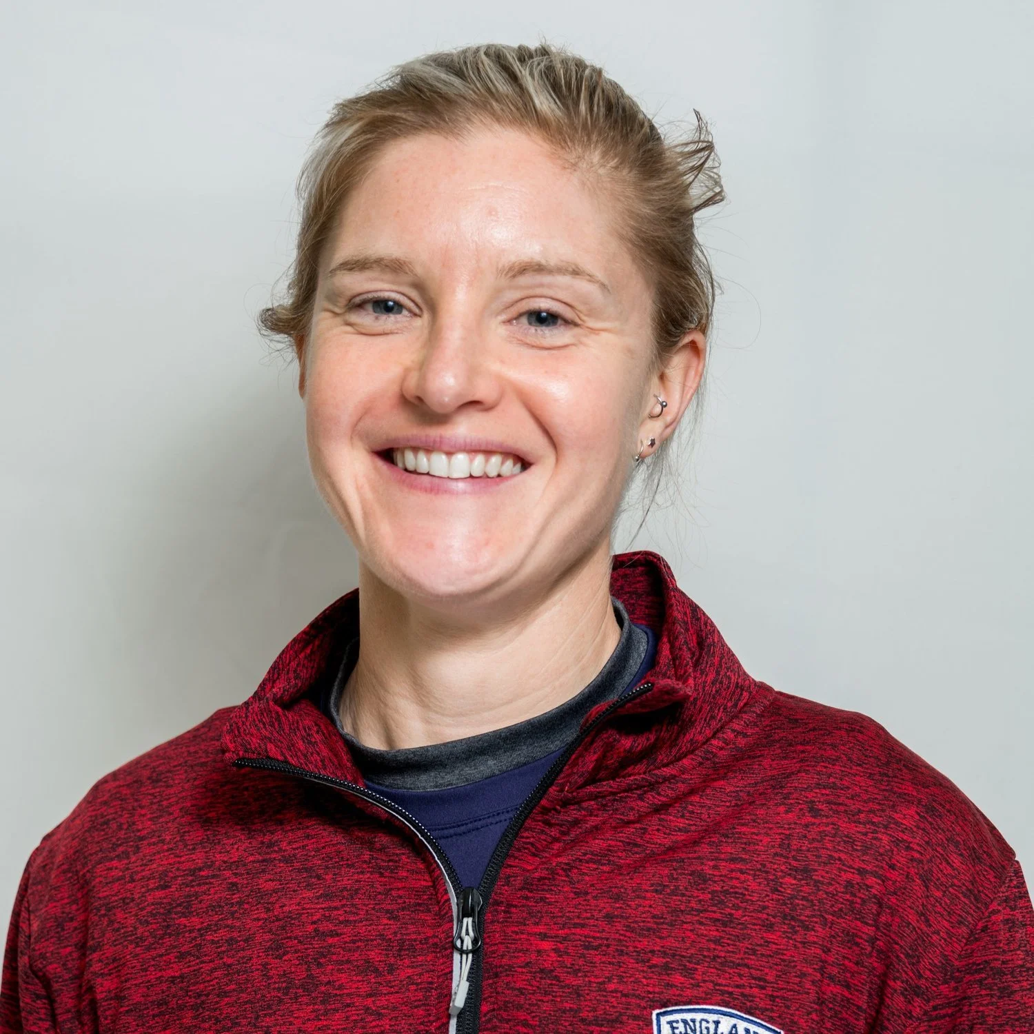 Person smiling, wearing a red jacket.