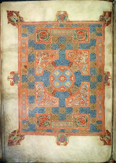 Illuminated manuscript page with intricate geometric and floral designs in red, blue, and gold hues, featuring Celtic knot patterns.