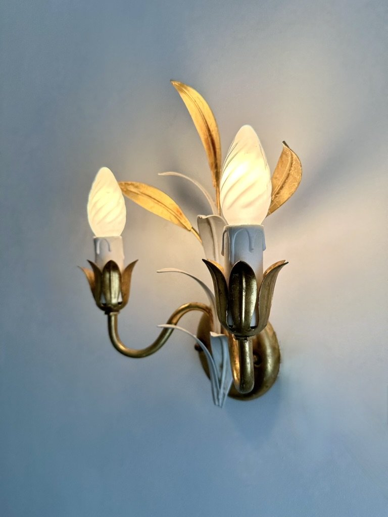 Side view of the matching Italian wall sconces showing their curved gilt arms, floral candle cups and depth from the wall.