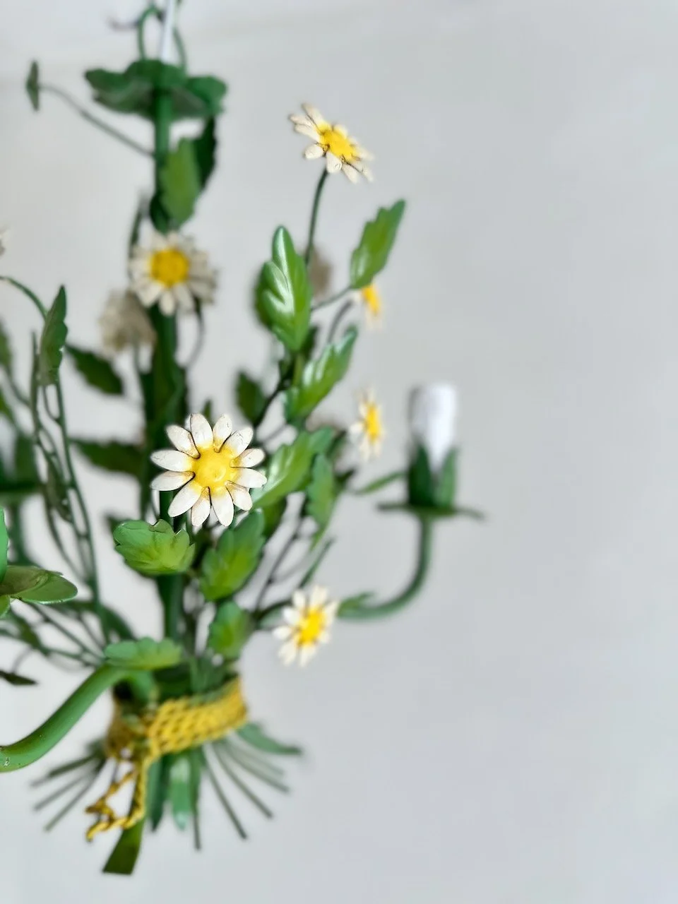 Side view of the vintage Italian floral chandelier showing painted white daisies, yellow centres and layered green metal leaves. IMG_7529.jpeg