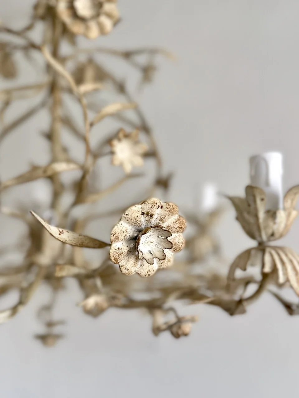 Close-up of cream painted metal flowers, buds and leaves on a mid-century Italian Florentine tole chandelier..jpeg