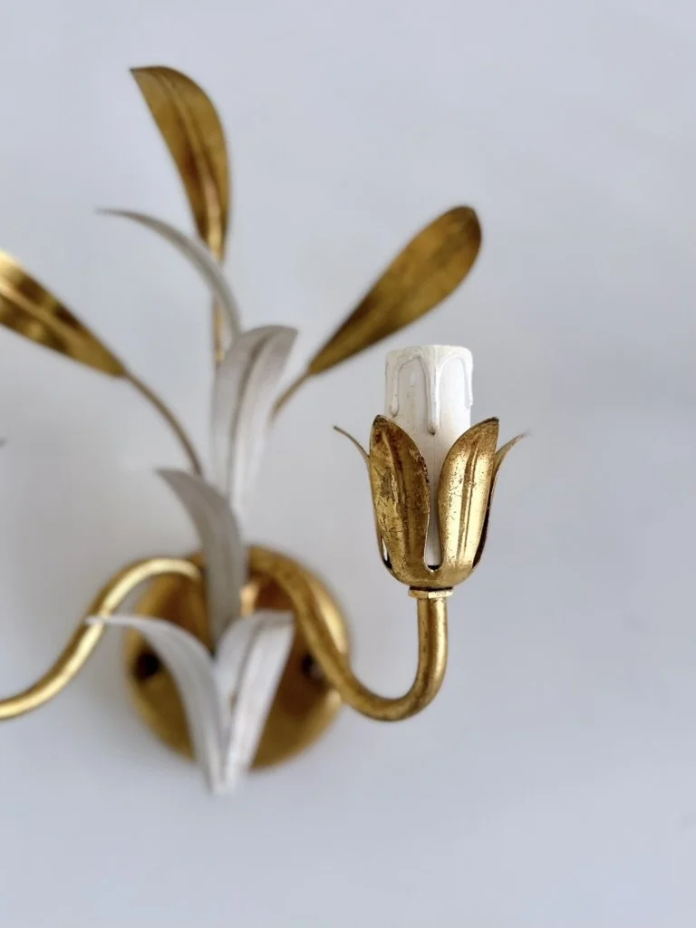 Close-up of the sculptural gold and white botanical leaves on a vintage Italian Masca tole wall light.