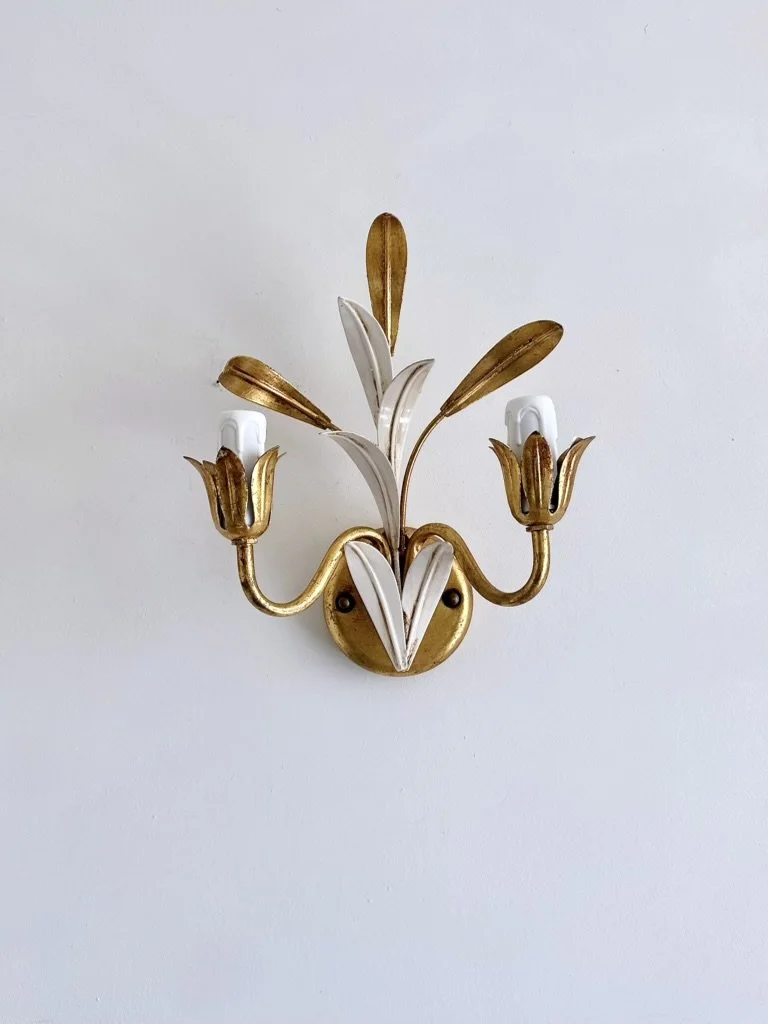 Close-up of the sculptural gold and white botanical leaves on a vintage Italian Masca tole wall light.