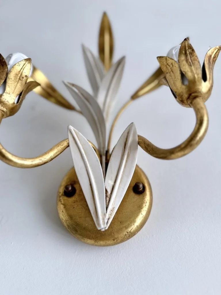 Angled view of a vintage Masca-style floral wall sconce showing its layered ivory leaves and sculptural gilt foliage.
