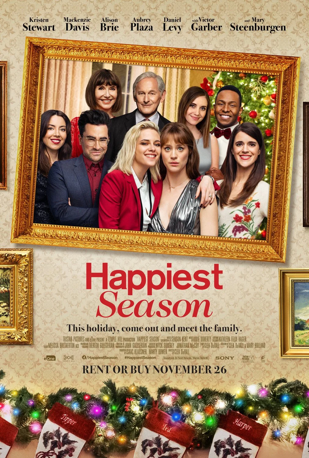 Poster for the movie 'Happiest Season' featuring a framed portrait of the main cast with holiday decorations. Text reads: "This holiday, come out and meet the family. Rent or buy November 26."