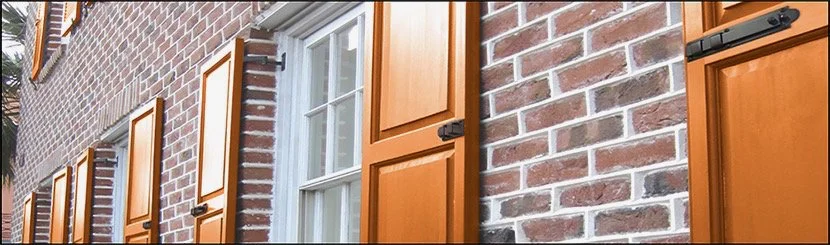 Brick building with orange window shutters