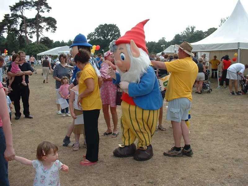 person in noddy character costumes surrounded by families