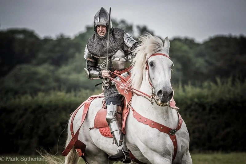 A knight in armour on a white horse