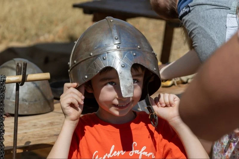 Child trying on Viking helmet