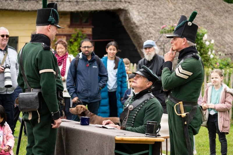 Re-enactors dressed as Napoleonic Riflemen demonstrate how soldiers were paid during the Napoleonic war