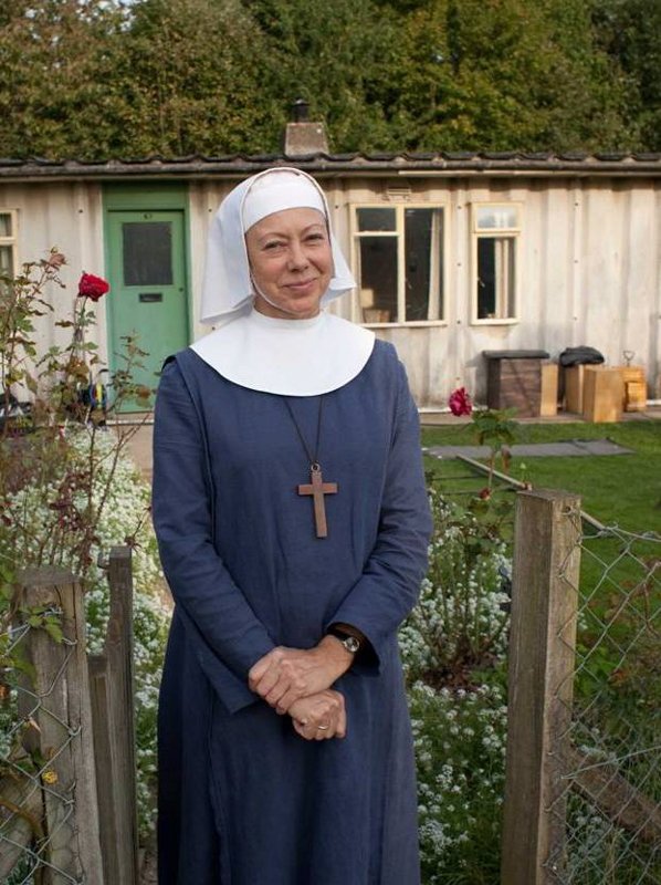 woman dressed as a nun outside prefab