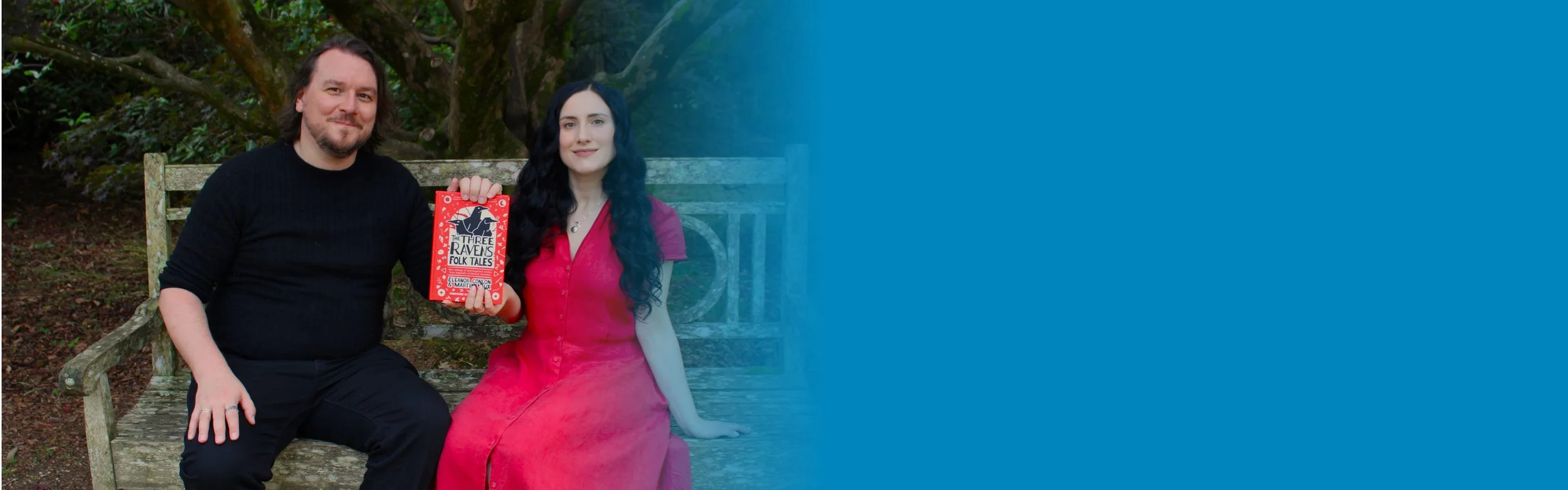 A man and a woman on a bench holding a book about folk tales