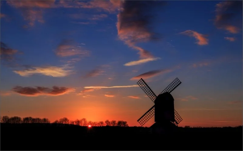 A windmill against a sunset sky