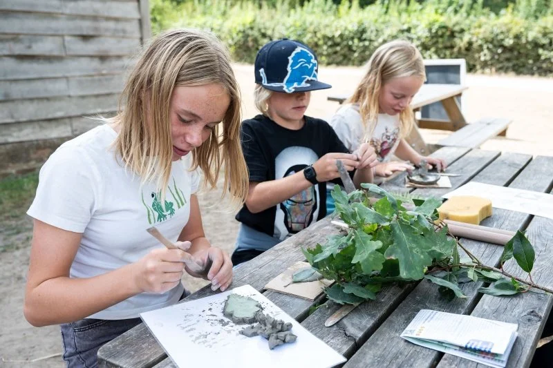 Three children creating claymakes inspired by leaves 