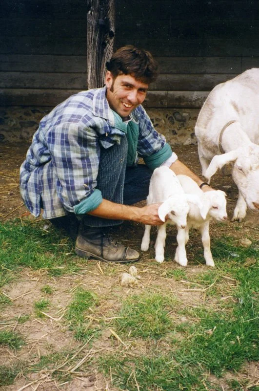 Man holding two baby goats