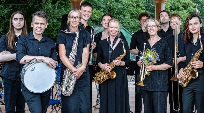 A group of jazz musicians stand smiling on the bandstand at Chiltern Open Air Museum