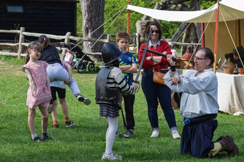A child tries on the helmet and armour of an English Civil War soldier