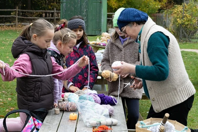 A group of teenage girls trying knitting